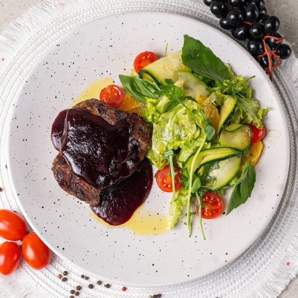 Антрекот з телятини з соусом чорної смородини та салатом з персика